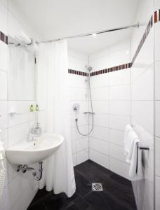 Un baño blanco con lavabo y ducha. en Hotel Central eGbR, en Würzburg