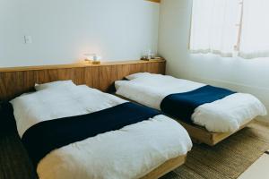 2 letti posti uno accanto all'altro in una stanza di Hostel Saruya a Fujiyoshida