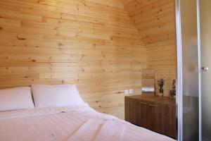 ein Schlafzimmer mit Holzwänden und ein Bett in einem Zimmer in der Unterkunft Mountain house Korab Trnica in Trnica