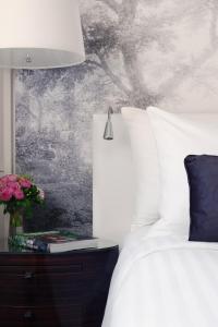 Un dormitorio con una cama y una mesa con un jarrón de flores en Renaissance Paris Nobel Tour Eiffel Hotel, en París
