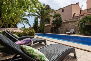 a group of chairs next to a swimming pool at Masia Notari Casabona in Vilanova i la Geltrú