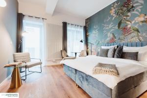a bedroom with a large bed with a painting on the wall at City-Studio mit Boxspring-Bett und Küche in Münster