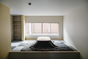 ein Zimmer mit einem Bett in der Mitte eines Zimmers mit einem Fenster in der Unterkunft 自由自屋 in Nachikatsuura