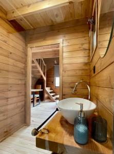 a bathroom with a white sink on a wooden wall at Mountain Eco Shelter 7 in Funchal