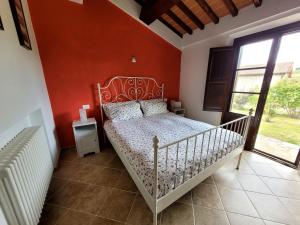 - une chambre dotée d'un lit avec un mur rouge dans l'établissement Podere San Luigi - Pet Friendly, à Volterra