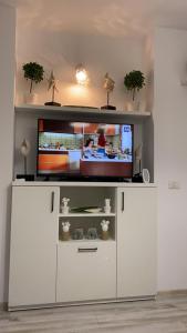 a white entertainment center with a flat screen tv on it at MG Mamaia North Villa in Mamaia Nord