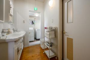ein weißes Badezimmer mit einem Waschbecken und einem Spiegel in der Unterkunft LuLu Manza in Onna