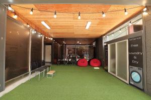 慶州市にあるStay RomanticTrip_Hostelの緑のカーペットフロアの広い客室で、建物内に位置しています。