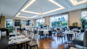 jadalnia ze stołami, krzesłami i oknami w obiekcie Istanbul Marriott Hotel Asia w Stambule