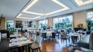 un comedor con mesas, sillas y ventanas en Istanbul Marriott Hotel Asia, en Estambul