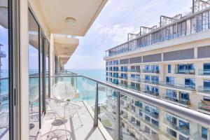 a balcony with chairs and a view of the ocean at Luxury 1BR Beachfront Apartment Marjan Island in Ras al Khaimah