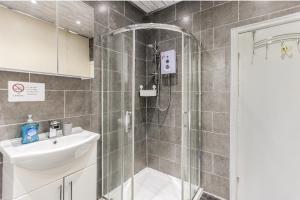 a bathroom with a shower and a sink at Spacious two bedroom house, parking and WiFi in Leeds +27 photos