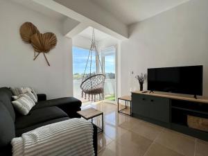 een woonkamer met een bank en een flatscreen-tv bij Apartamento Mogro in Miengo