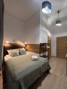 1 dormitorio con 1 cama grande y cabecero de madera en AMBER Guest Rooms, en Cracovia