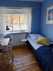 sypialnia z łóżkiem i oknem w obiekcie Guesthouse Hugo w mieście Sørvágur