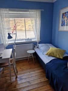 a bedroom with a bed and a window at Guesthouse Hugo in Sørvágur