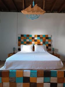 a bedroom with a large bed with a colorful headboard at Avó da Rosa 3 in Povoação +6 photos