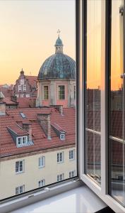 een open raam met uitzicht op een gebouw bij Mariacka Residence in Gdańsk