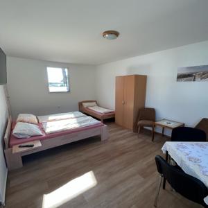 um quarto com 2 camas, uma mesa e cadeiras em Ferienpark Buntspecht Apartment B em Pruchten