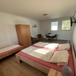 1 dormitorio con 2 camas y mesa. en Ferienpark Buntspecht Apartment B, en Pruchten