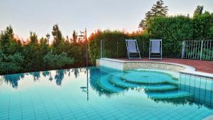 uma piscina com duas cadeiras na água em DIMORA SAN JACOPO 20&1, Emma Villas em Palaia