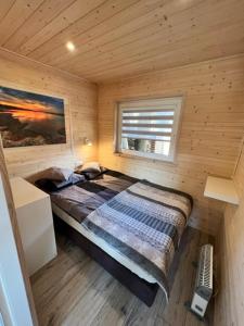 una camera con un letto in una cabina di legno di Domki Albertówka - Strefa Relaksu a Ostrowo