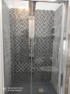 y baño con ducha y puerta de cristal. en PRESTIGE casa vacanze, en Catanzaro