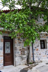un arbre devant un bâtiment avec une porte dans l'établissement Selena Guest House, à Krásion