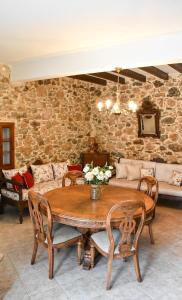 a dining room with a table and a stone wall at Selena Guest House in Krásion