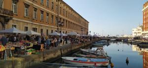 a group of people at an outdoor market next to a canal at Freetime Trieste in Trieste