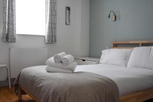 Un dormitorio con dos toallas en una cama. en The Old Coach House: Luxury Harbourside Apartment, en Bristol
