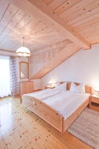 una camera con un grande letto in un soffitto in legno di Haslbauer a Steinbach am Attersee
