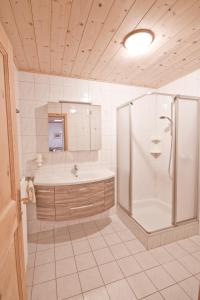ein großes Bad mit einer Dusche und einem Waschbecken in der Unterkunft Haslbauer in Steinbach am Attersee