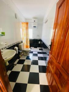 a bathroom with a black and white checkered floor at Motel Ain Mersa in Ifrane