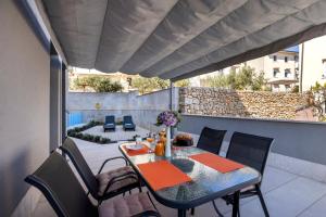patio ze stołem i krzesłami na balkonie w obiekcie Apartment Medea, St. Martin w miejscowości Mali Lošinj