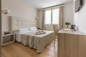 a hotel room with a bed and a table and a desk at Hotel Catalunya in Alghero +37 photos