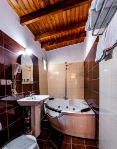 a bathroom with a tub and a sink at Kipos Resort in Nea Peramos