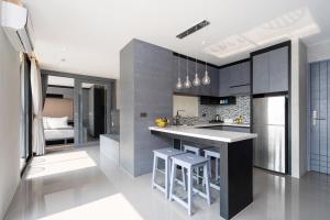 a kitchen with a counter and some stools in it at Tropics Kamala 2BR Pool View Apartment CTG B705-6 in Kamala Beach