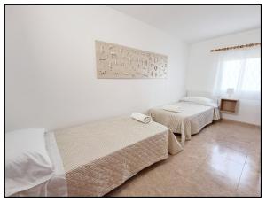 a bedroom with two beds and a painting on the wall at APARTAMENTO CENTRICO JUNTO AL MAR - WIFI FREE in Salou