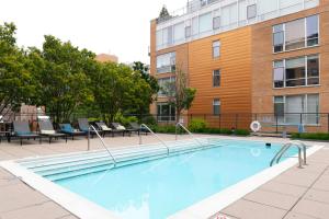 a large swimming pool with chairs and a building at Evanston 1BR w Pool Gym nr Nwestern CHI-702 in Evanston