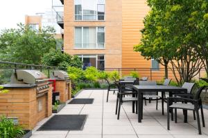 a patio with tables and chairs and a grill at Evanston 1BR w Pool Gym nr Nwestern CHI-702 in Evanston
