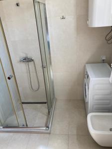 een badkamer met een douche, een toilet en een wastafel bij Apartman Edi 1 in Bar