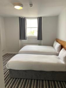 um quarto com duas camas e uma janela em Palace Court Hotel em Londres