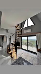 a living room with a staircase and large windows at Olympos Bungalov & Villa in Dalaman