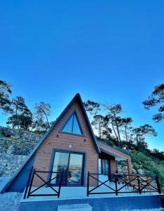 a small house with a pointed roof and windows at Olympos Bungalov & Villa in Dalaman