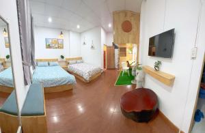 a room with two beds and a flat screen tv at Suri's House Homestay in Da Lat
