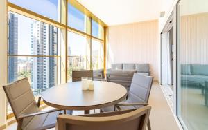 a dining room with a table and chairs and windows at Intempo Sky Apartments 056 in Benidorm