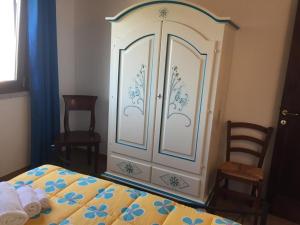 斯廷蒂諾的住宿－Villa paradiso，卧室配有白色橱柜,上面有蓝色的鲜花
