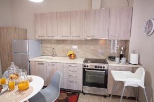 a kitchen with a stove and a table with chairs at Marialena Apartment by RentalsPro - Nea Moudania in Nea Moudania