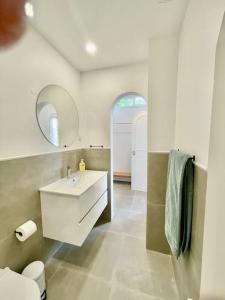 een badkamer met een wastafel, een toilet en een spiegel bij Beautiful apartment In historic center in Lissabon